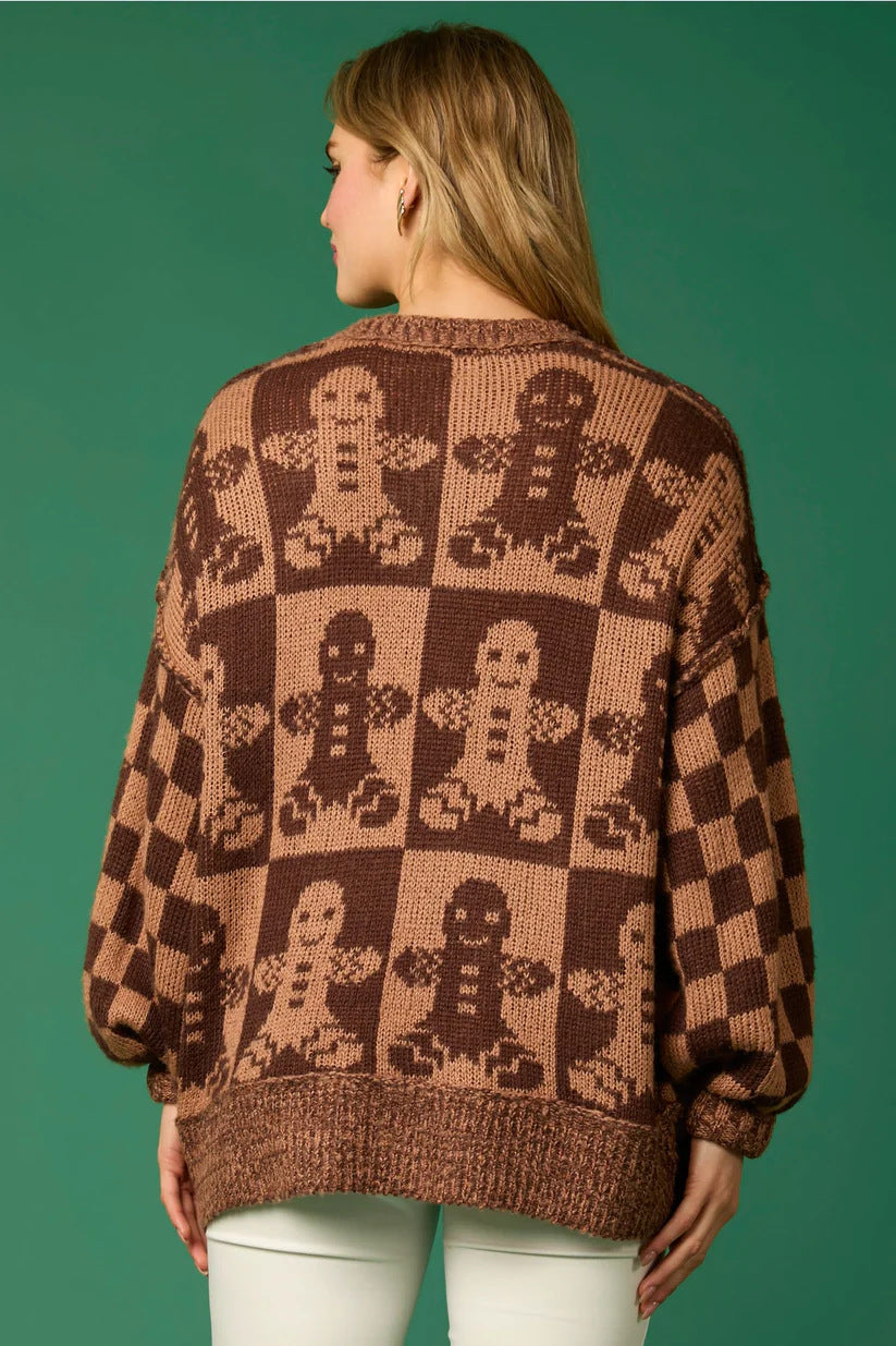 Pull tricoté avec des épingles de Noël en forme de canne à sucre et un bonhomme en pain d'épices