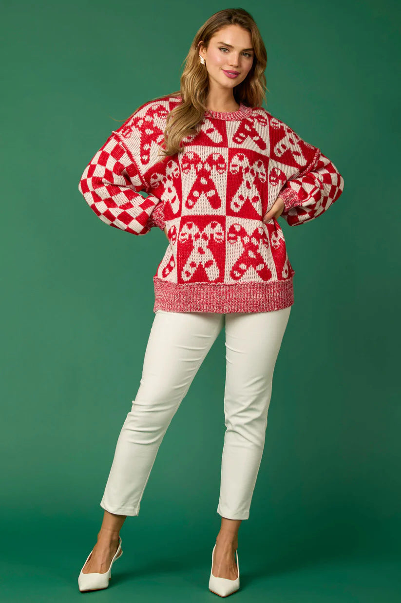 Pull tricoté avec des épingles de Noël en forme de canne à sucre et un bonhomme en pain d'épices